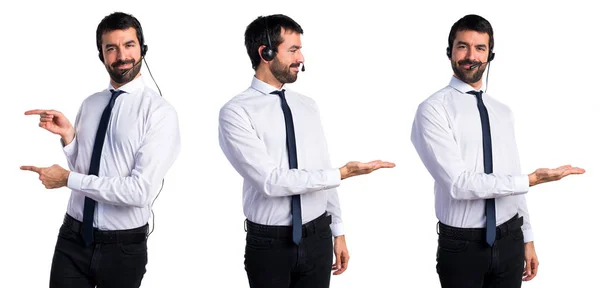 Jeune homme avec un casque présentant quelque chose — Photo