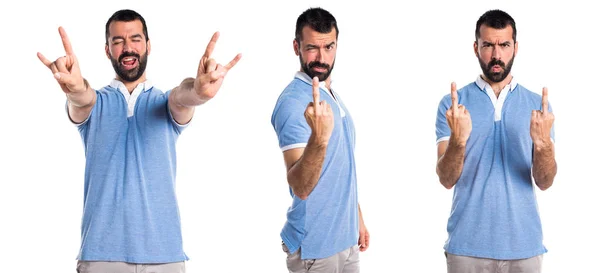 Homem com camisa azul fazendo gesto chifre — Fotografia de Stock