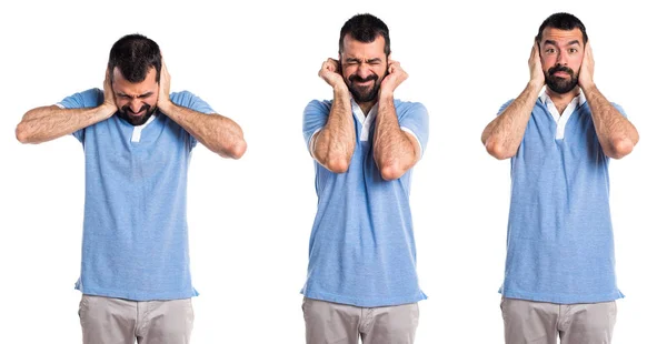 Homem com camisa azul cobrindo seus ouvidos — Fotografia de Stock