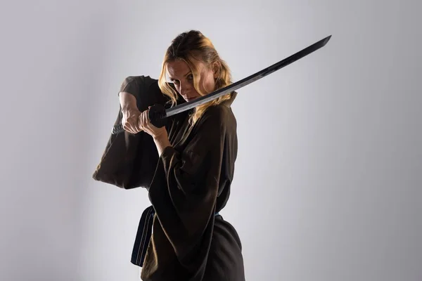 Mulher loira vestida como samurai com uma katana — Fotografia de Stock