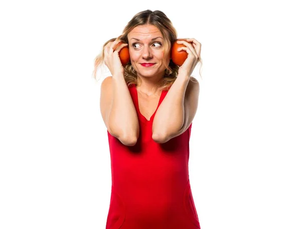 Schöne blonde Frau, die Tomaten hält — Stockfoto