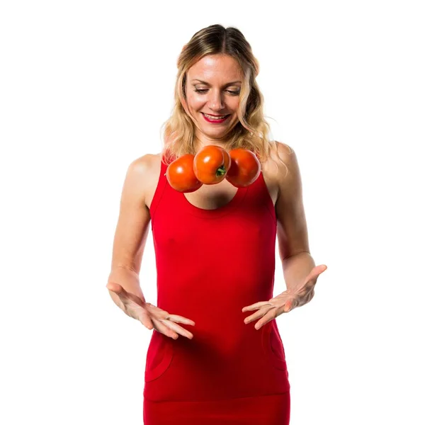 Schöne blonde Frau, die Tomaten hält — Stockfoto