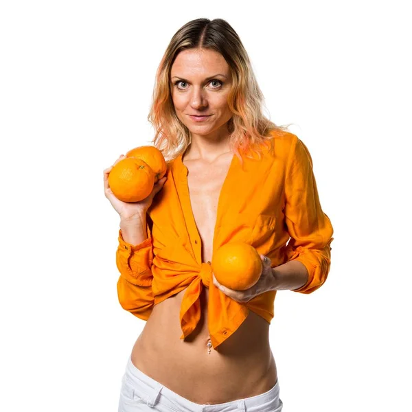 Beautiful blonde woman holding oranges — Stock Photo, Image