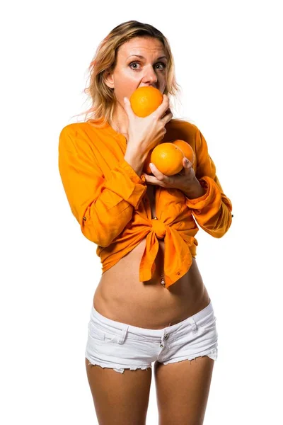 Hermosa mujer rubia sosteniendo naranjas — Foto de Stock