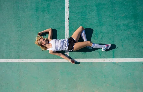 Csinos nő feküdjön a padlóra focipálya — Stock Fotó