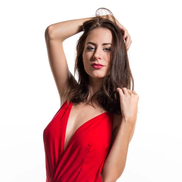 Το όμορφο μοντέλο γυναίκα που παρουσιάζουν στο στούντιο με ένα σέξι κόκκινο φόρεμα — Φωτογραφία Αρχείου