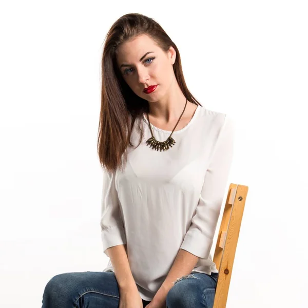 Young pretty model woman posing in studio on chair — Stock Photo, Image