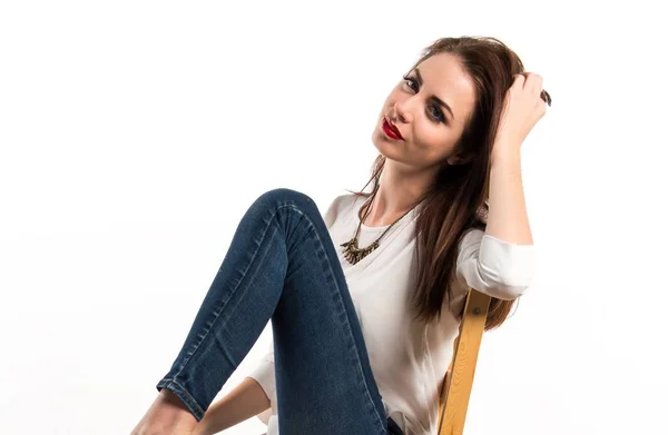 Молода красива модель жінка позує в студії на стільці — стокове фото