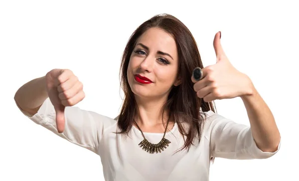 Pretty young girl making good-bad sign — Stock Photo, Image