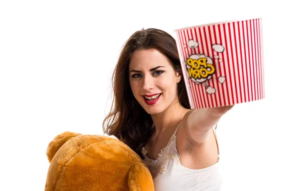 Glückliches Mädchen mit Schlafanzug und einer Schüssel Popcorn beim Spielen mit einem Stofftier — Stockfoto