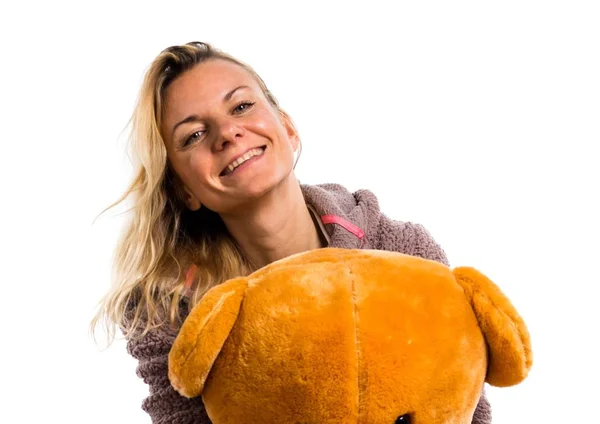 Mooie blonde meisje in schattige pyjama met grote Knuffeldier — Stockfoto