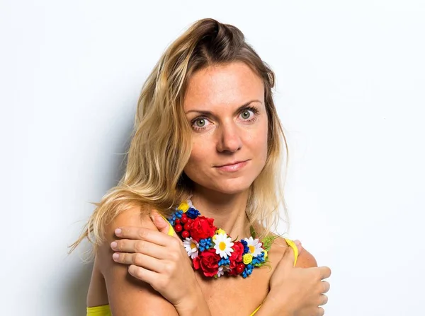 Mulher modelo bonito posando em estúdio com um colar de flores coloridas — Fotografia de Stock