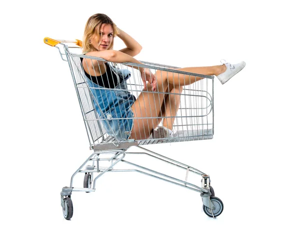 Mujer bonita dentro de un carrito de supermercado — Foto de Stock