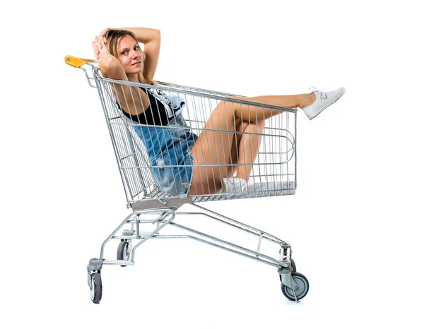 Mulher bonita dentro de um carrinho de supermercado — Fotografia de Stock