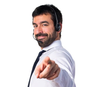 Öne doğru işaret eden bir kulaklık ile genç adam