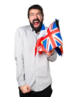 Birçok bayrak tutan ve bağırarak sakallı yakışıklı adam