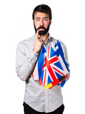 Birçok bayrak tutan sakallı üzgün yakışıklı adam