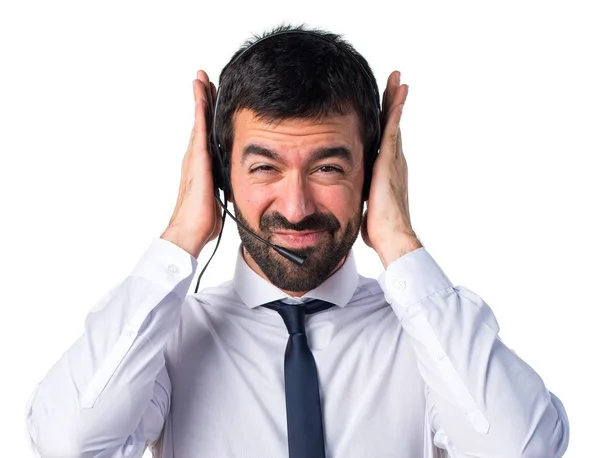 Młody człowiek z zestawem słuchawkowym, obejmujące jego uszy — Zdjęcie stockowe