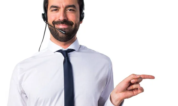 Young man with a headset pointing to the lateral — Stock Photo, Image