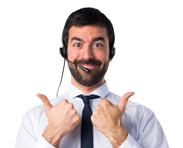 Young man with a headset with thumb up — Stock Photo, Image