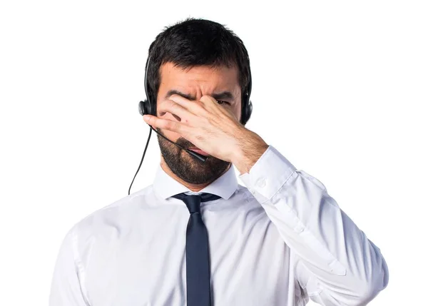 Joven con un auricular oliendo mal gesto —  Fotos de Stock