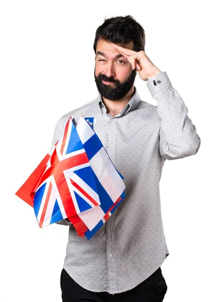 Birçok bayrak tutan ve selamlayan sakallı yakışıklı adam — Stok fotoğraf