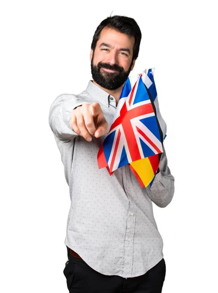 많은 깃발을 들고와 앞을 가리키는 수염과 잘생긴 남자 — 스톡 사진