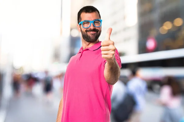 Man in kleurrijke kleding met duim omhoog — Stockfoto