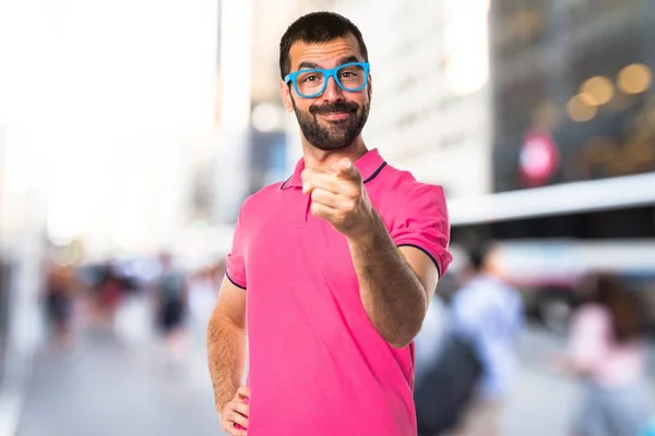 Человек в разноцветной одежде указывает на переднюю — стоковое фото