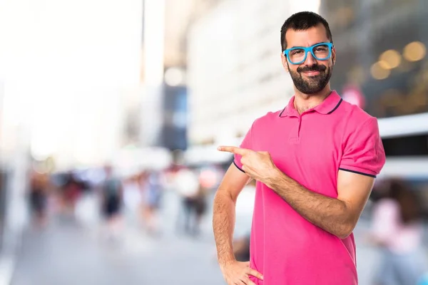Człowiek z kolorowe ubrania, wskazując na boczne — Zdjęcie stockowe