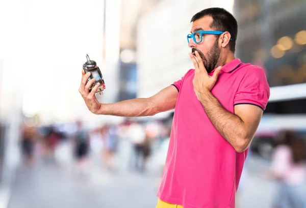 Homme avec des vêtements colorés tenant horloge vintage — Photo