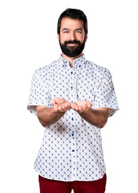 Bir şey tutan sakallı yakışıklı esmer adam