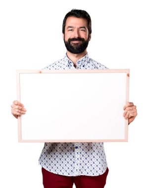 Boş bir afiş tutarak sakallı yakışıklı esmer adam