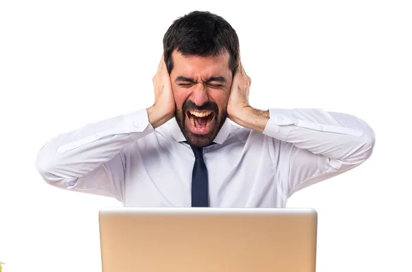 Businessman in his office covering his ears — Stock Photo, Image