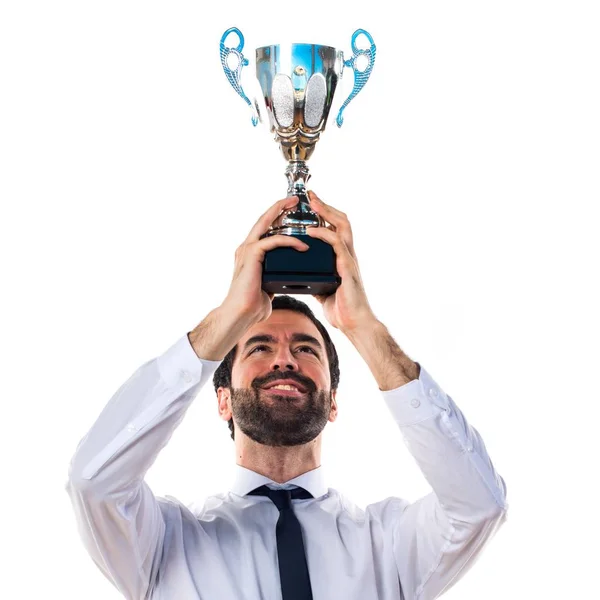 Businessman in his office holding a trophy — Stock Photo, Image