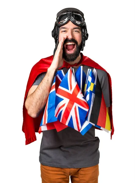 Superhéroe con un montón de banderas gritando — Foto de Stock