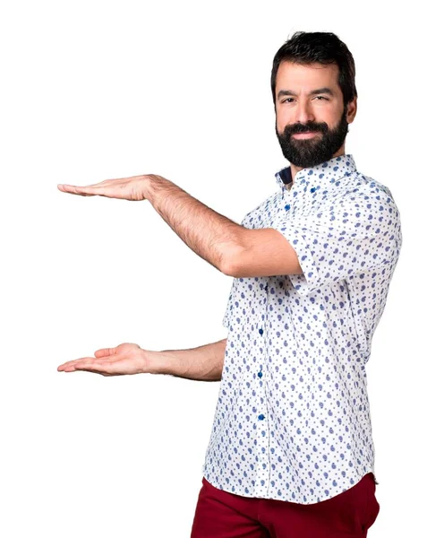 Handsome brunette man with beard holding something — Stock Photo, Image