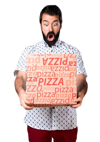 Schöner brünetter Mann mit Bart, der eine Pizza hält — Stockfoto