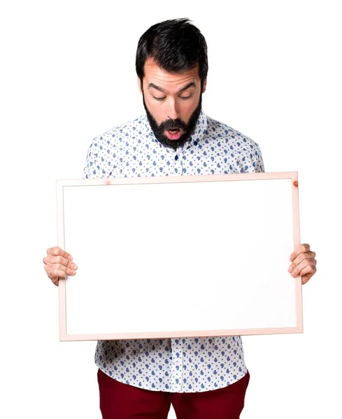 Hezký brunetka muž s plnovousem drží prázdné cedulky — Stock fotografie