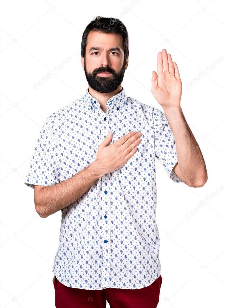 Handsome brunette man with beard making an oath