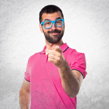 Renkli giysiler dokulu gri cephesinde işaret eden adamla