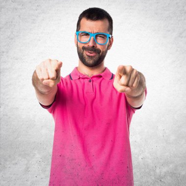 Renkli giysiler dokulu gri cephesinde işaret eden adamla