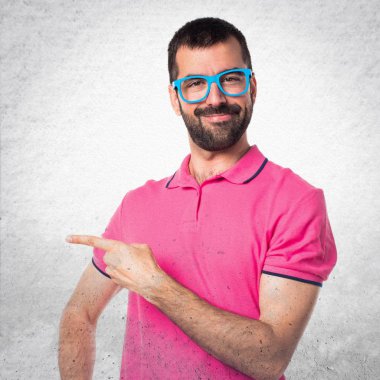 Renkli elbise gri textur üzerinde lateral işaret eden adamla