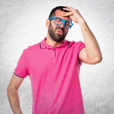 Gri dokulu arka plan üzerinde renkli giysileri ile sinirli adam