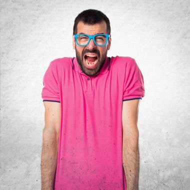 Gri dokulu arka plan üzerinde renkli giysileri ile sinirli adam