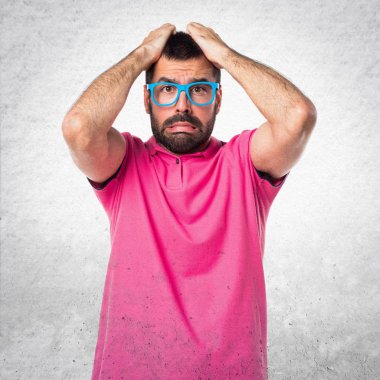 Gri dokulu arka plan üzerinde renkli giysileri ile sinirli adam