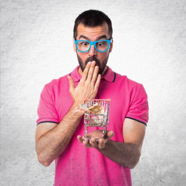 Adam tutmak ile bir süpermarket arabası oyuncak renkli giysileri ile bir 