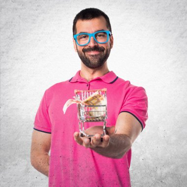 Adam tutmak ile bir süpermarket arabası oyuncak renkli giysileri ile bir 