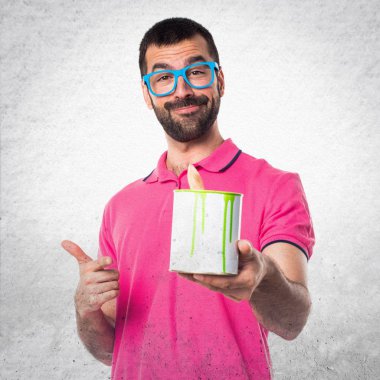 Renkli elbise gri dokulu b bir boya potu tutan adamla