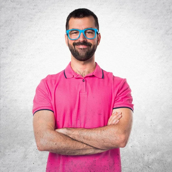 Man in colorful clothes with his arms crossed on grey textured b — Stock Photo, Image